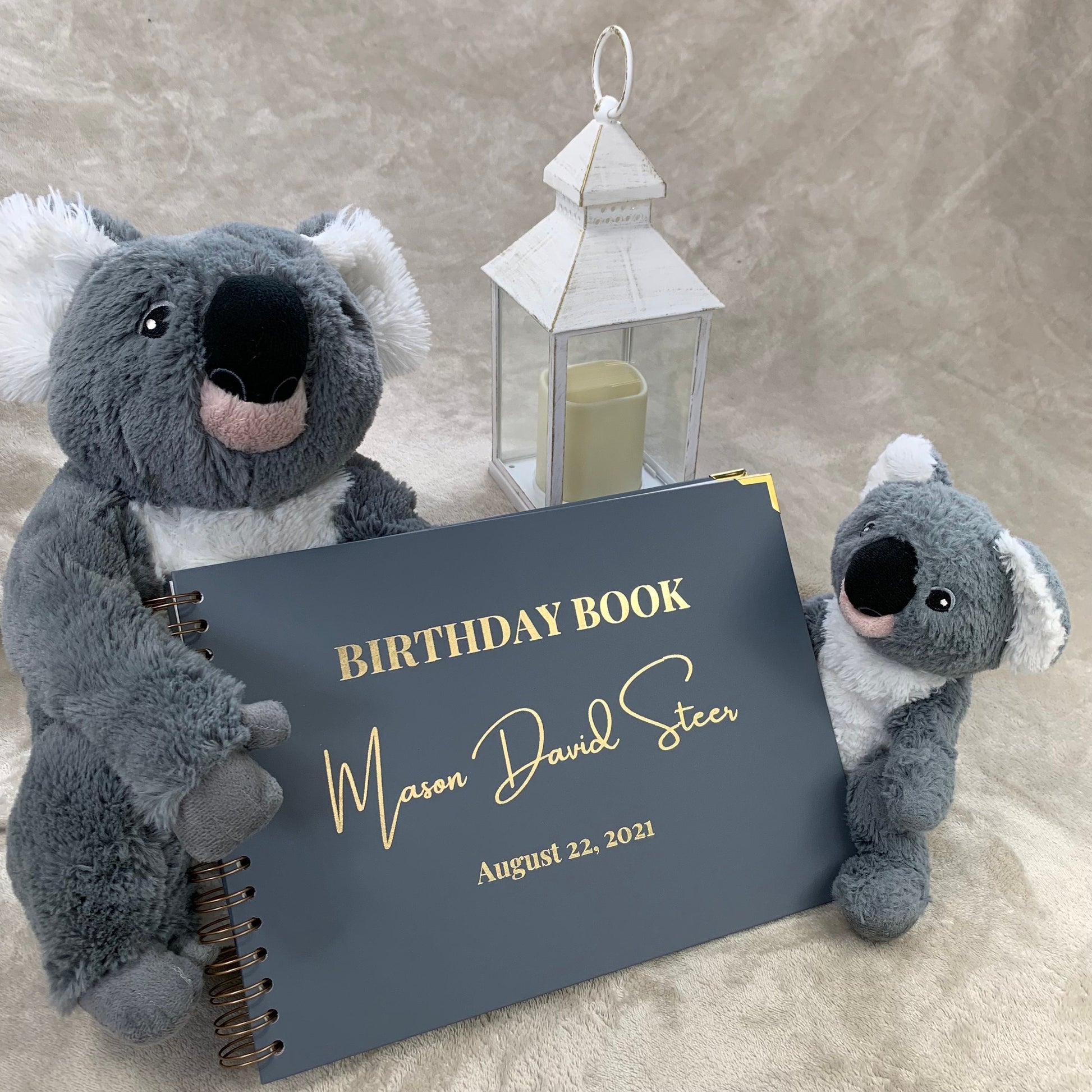 A blue/Grey birthday book with the words 'Birthday Book Mason David Steer August 22nd 2021' in gold foil