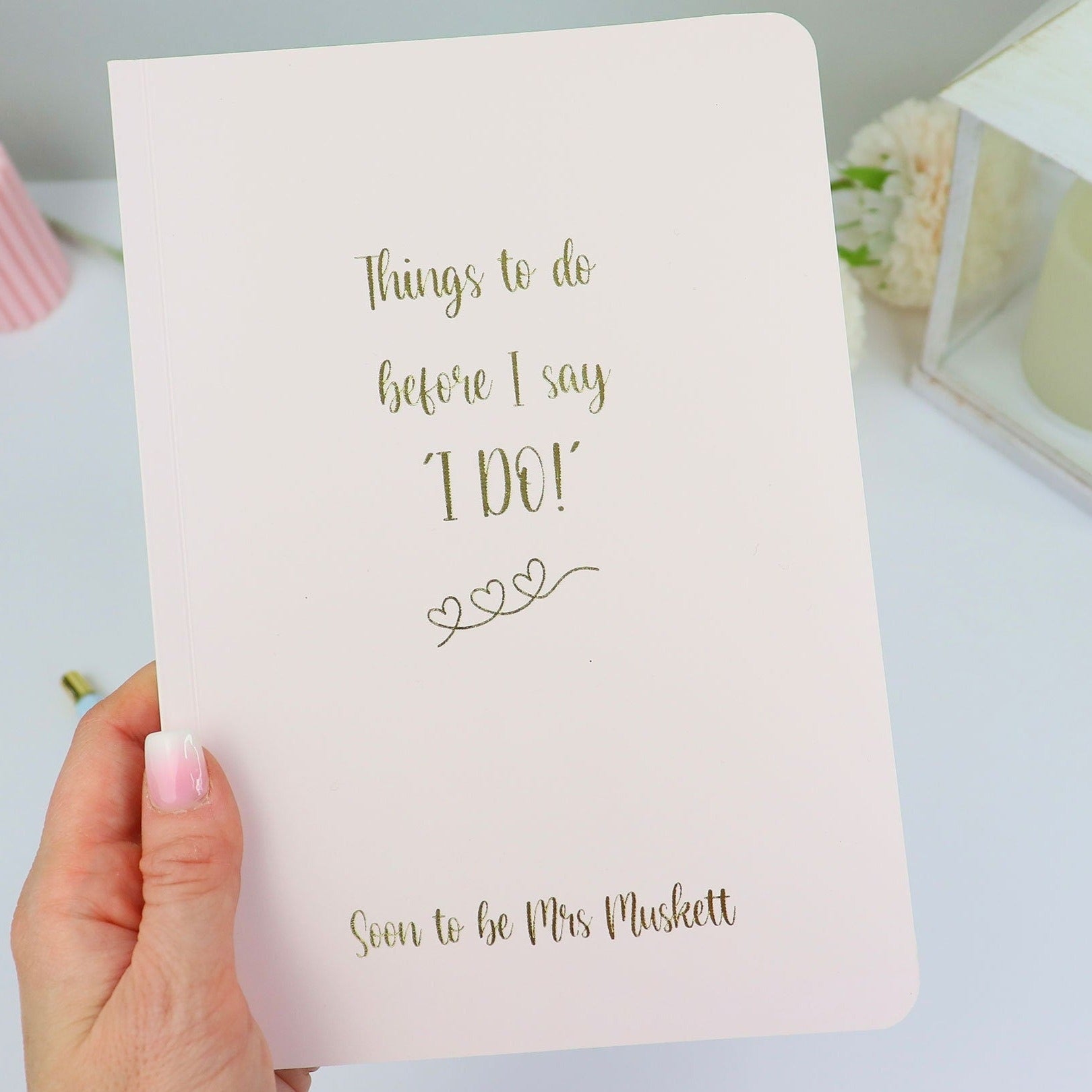 An A5 softback notebook in Pale Pink that says 'Things to do before I say I do, Soon to be Mrs Muskett' in gold foil
