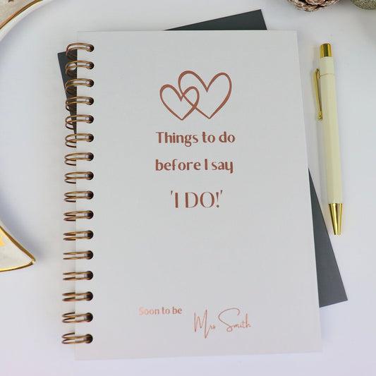 light grey hardback notebook that says 'Things to do before I say I do, Soon to be Mrs Smith' in bronze foil