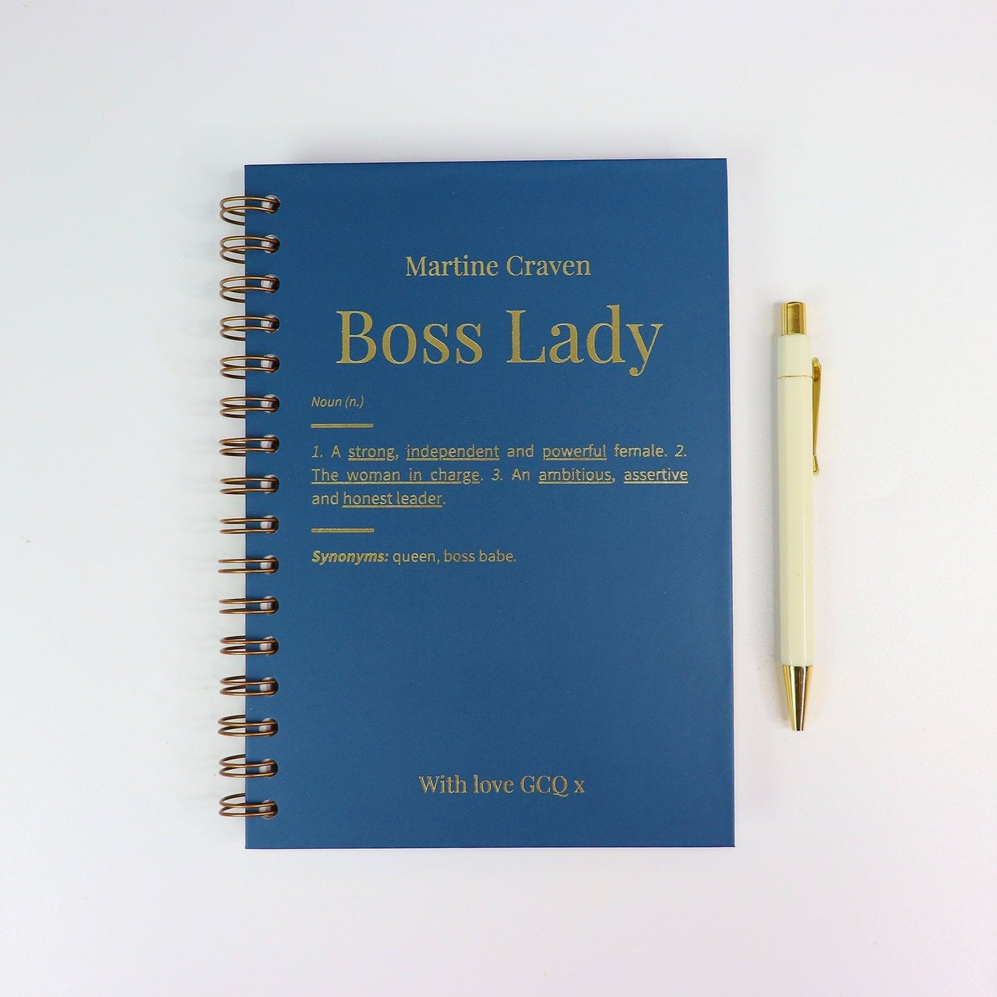 An A5 notebook in midnight blue that says 'Boss Lady' with the personas name above and a dictionary type description of what a boss lady is All in gold foil.