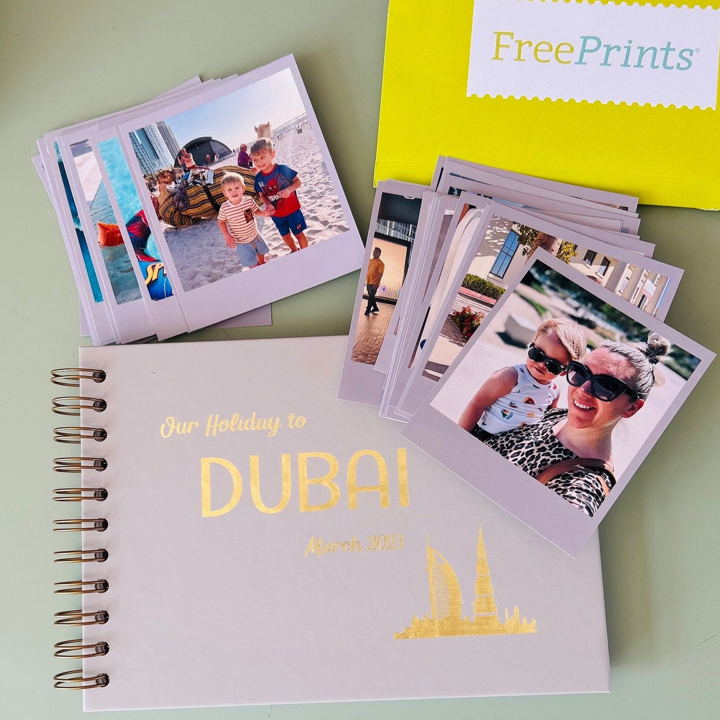 A5 hardback book in a stone colour that says Our Holiday to Dubai in gold foil and there are pictures of a holiday surrounding the book