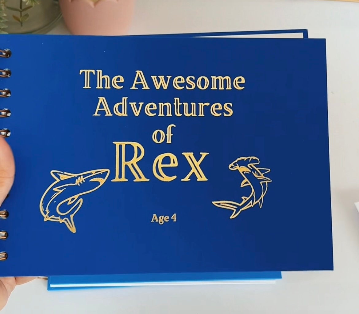 A5 memory book in Sea Blue colour. It says 'The Awesome Adventures of Rex Age 4 with two images of sharks al in gold foil