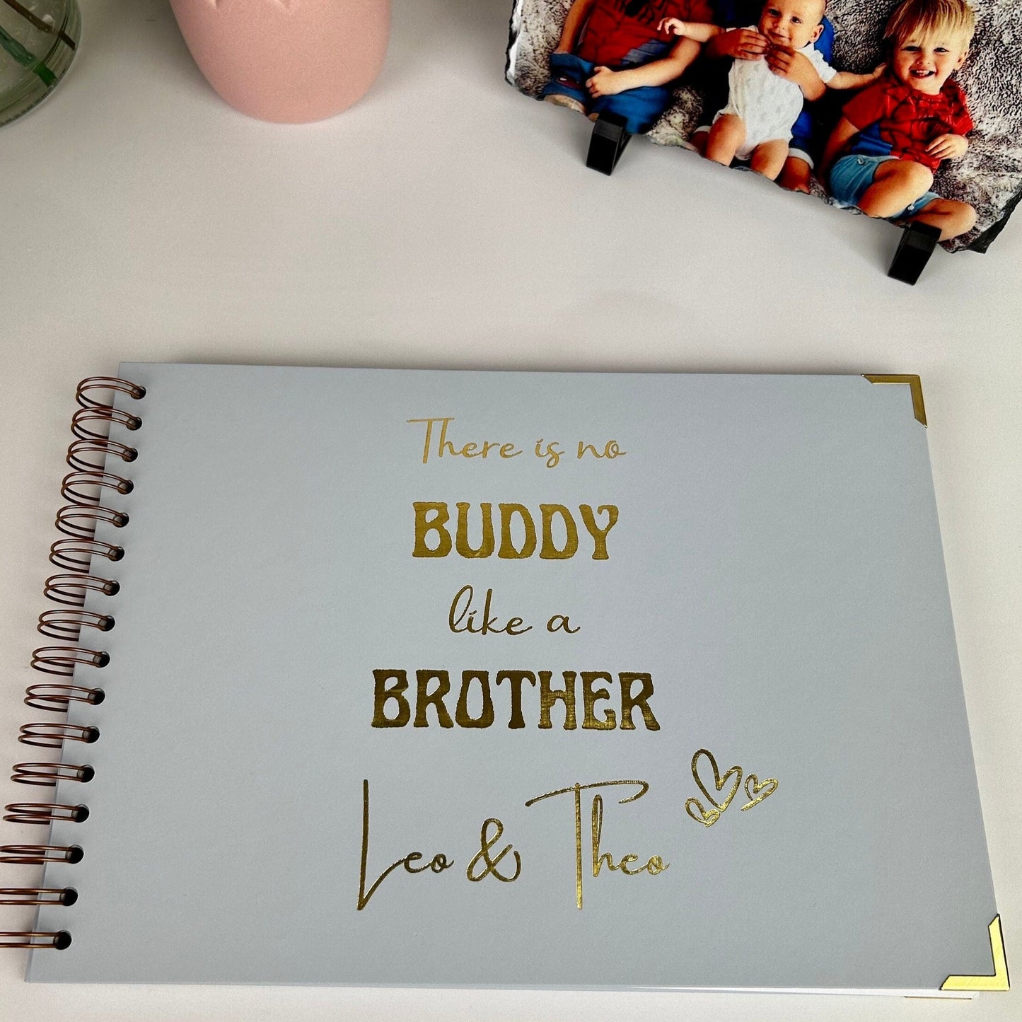 An A4 ice blue colour memory book with the writing 'There is no buddy like a brother Leo & Theo' in gold foiling