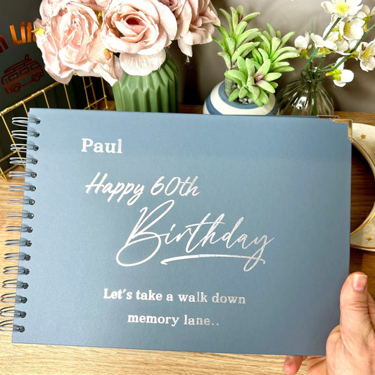 An A4 blue/grey memory book with the words 'Paul Happy 60th Birthday, Lets take a walk down memory Lane..' in silver foil