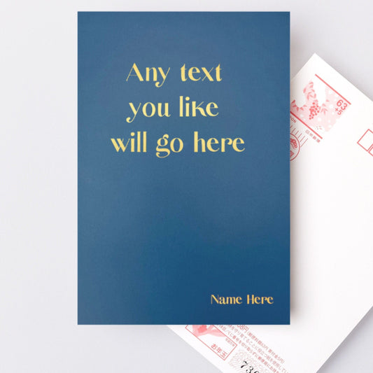 A hardback A5 notebook in midnight blue thats says 'Any text you like will go here' in gold foil